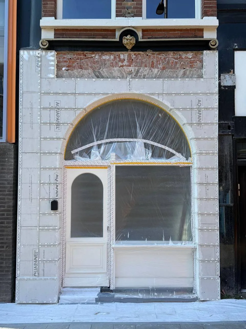 Winkelpui met een boog, verweerd tegelwerk en oude kozijnen, voor het stucwerk