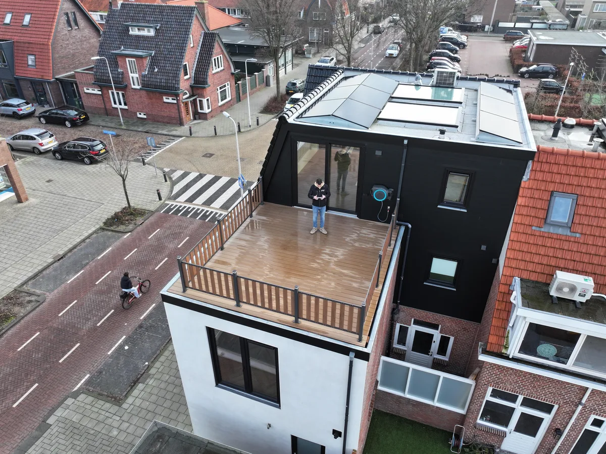 Luchtfoto van het dakterras op de woning, met de vlonder en het hekwerk