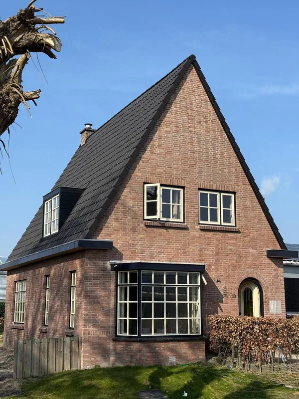 Dezelfde woning met een nieuw donker pannendak en een vernieuwde dakkapel