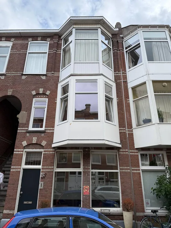 Bakstenen herenhuis met een witte erker en nieuwe witte kozijnen