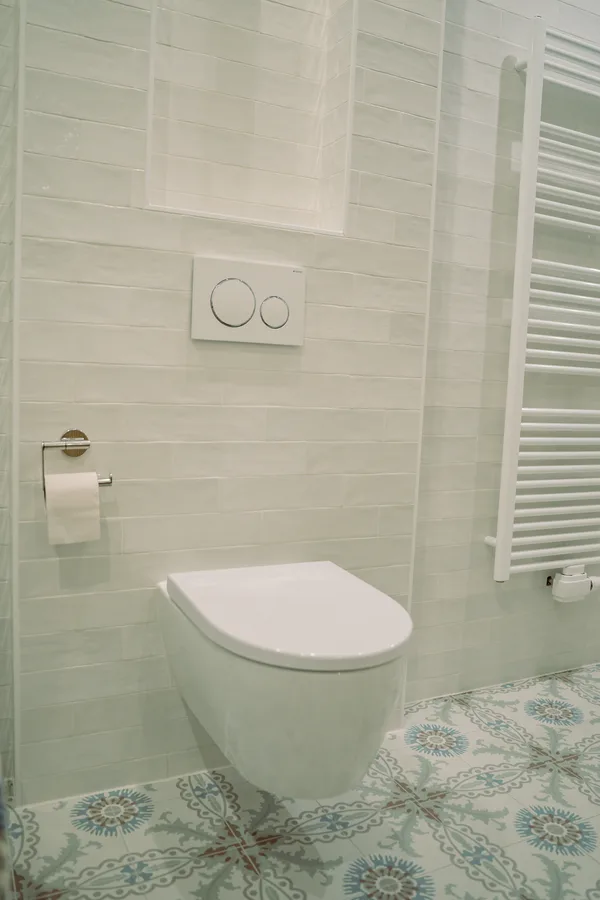 Hangtoilet met bedieningsplaat, met een handdoekradiator ernaast